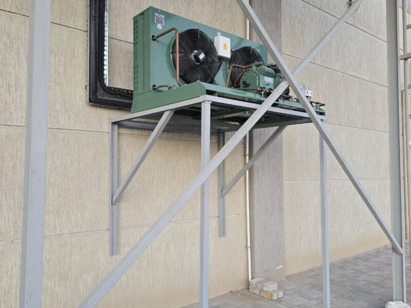 Air-cooled condensing unit installed on a fabricated steel support frame at a Dubai cold store facility