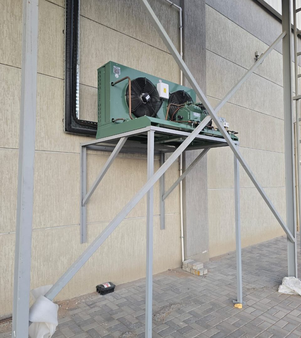 Air-cooled condensing unit installed on a fabricated steel support frame at a Dubai cold store facility