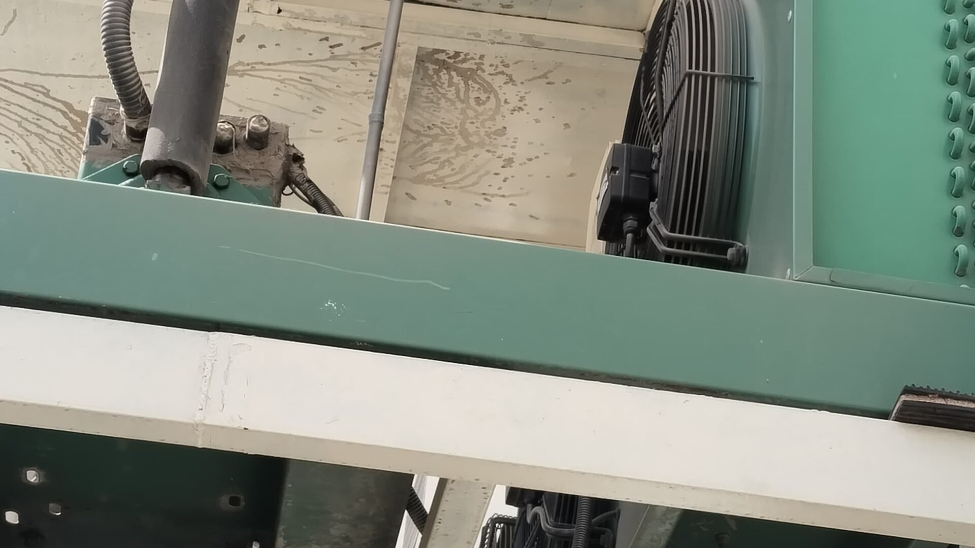 Underside view of an air-cooled condensing unit on a steel support frame with insulated suction pipework