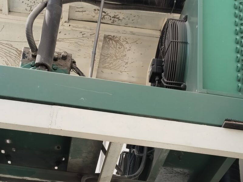 Underside view of an air-cooled condensing unit on a steel support frame with insulated suction pipework