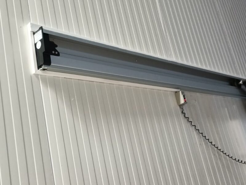 Air curtain installed above a cold room door opening to control warm air infiltration