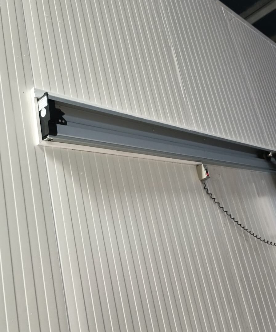 Air curtain installed above a cold room door opening to control warm air infiltration