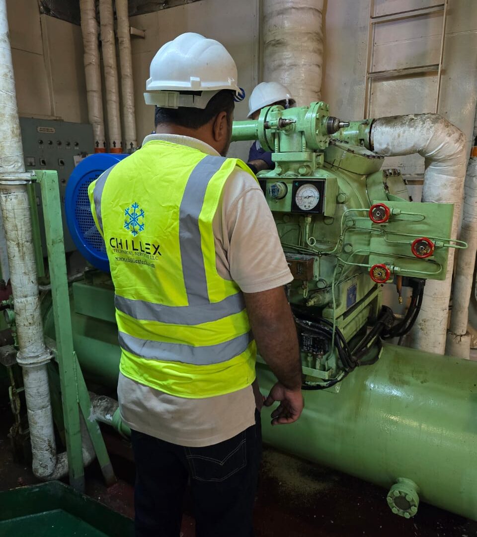 Chillex technicians in branded PPE servicing a reciprocating provision plant compressor in a vessel machinery space