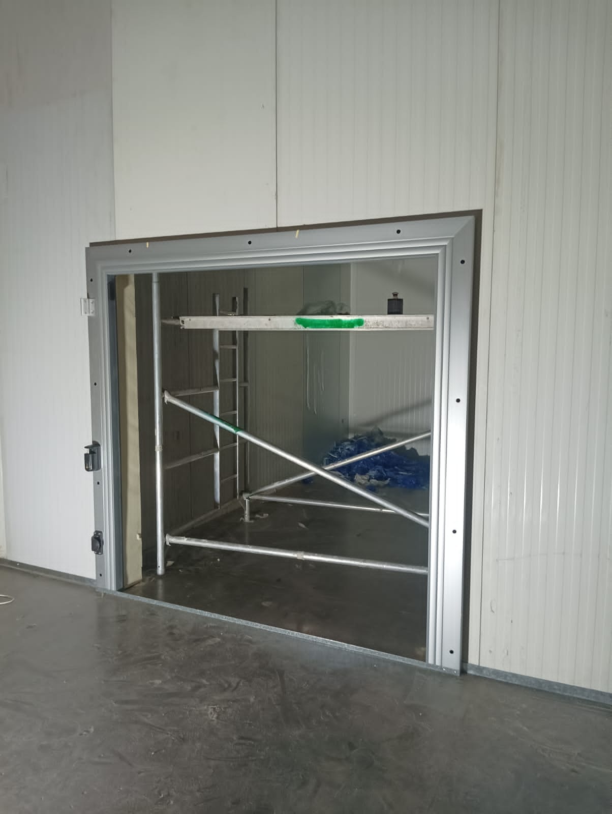 Insulated cold room door being installed during a Chillex panel build