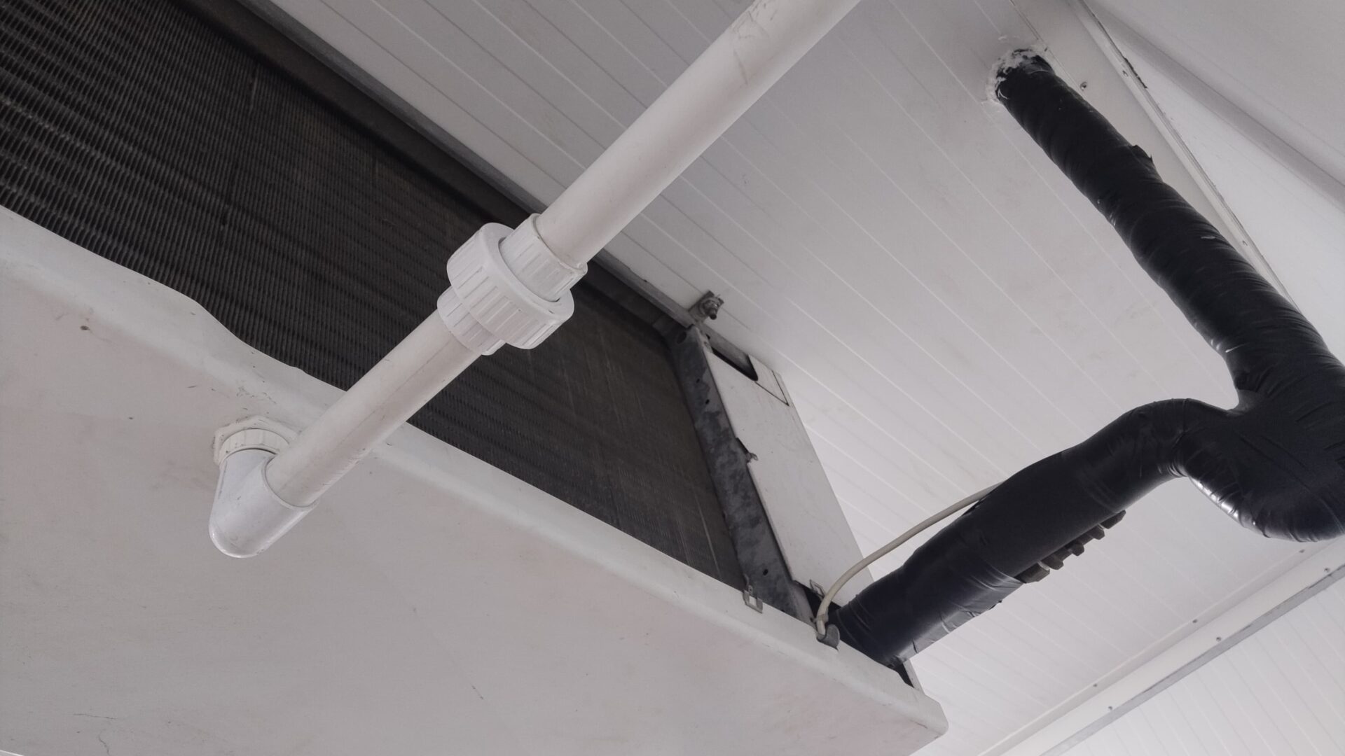 Cold room ceiling showing evaporator drainage pipework and insulated refrigerant lines