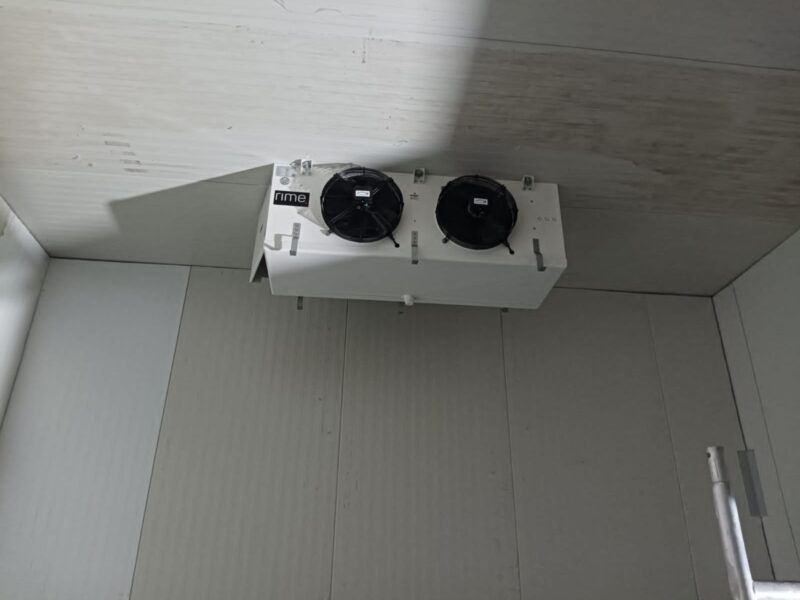 Twin-fan unit cooler evaporator installed in a white insulated panel cold room