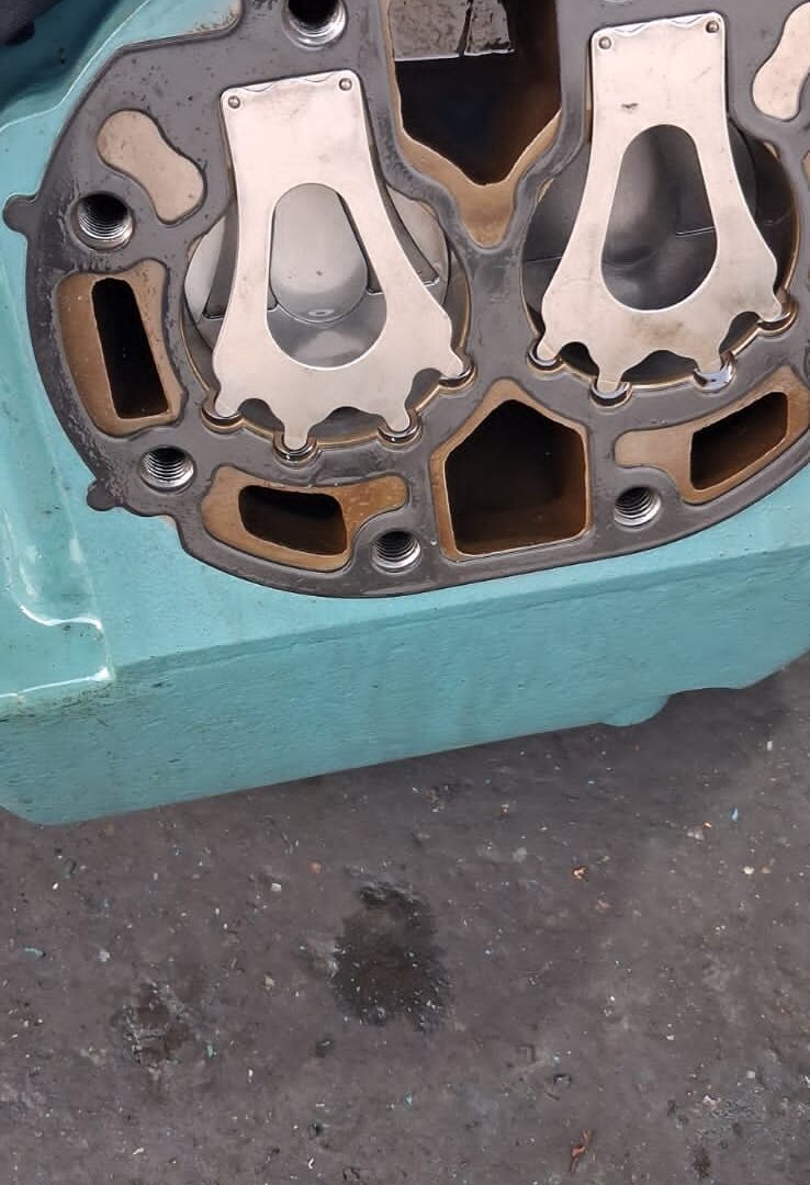 Compressor cylinder head removed showing valve seats and gasket face during overhaul