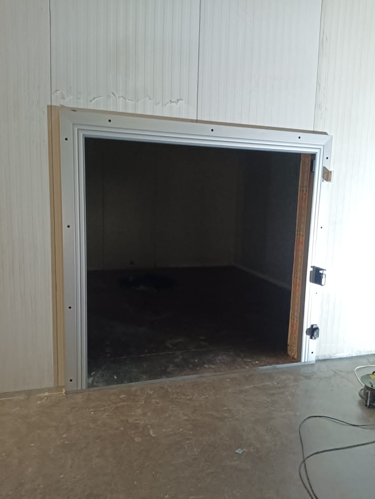 Insulated cold room door frame fitted into a polyurethane panel wall