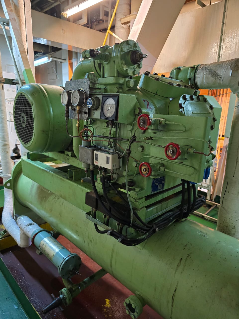 Marine reciprocating refrigeration compressor and receiver assembly in a vessel engine room