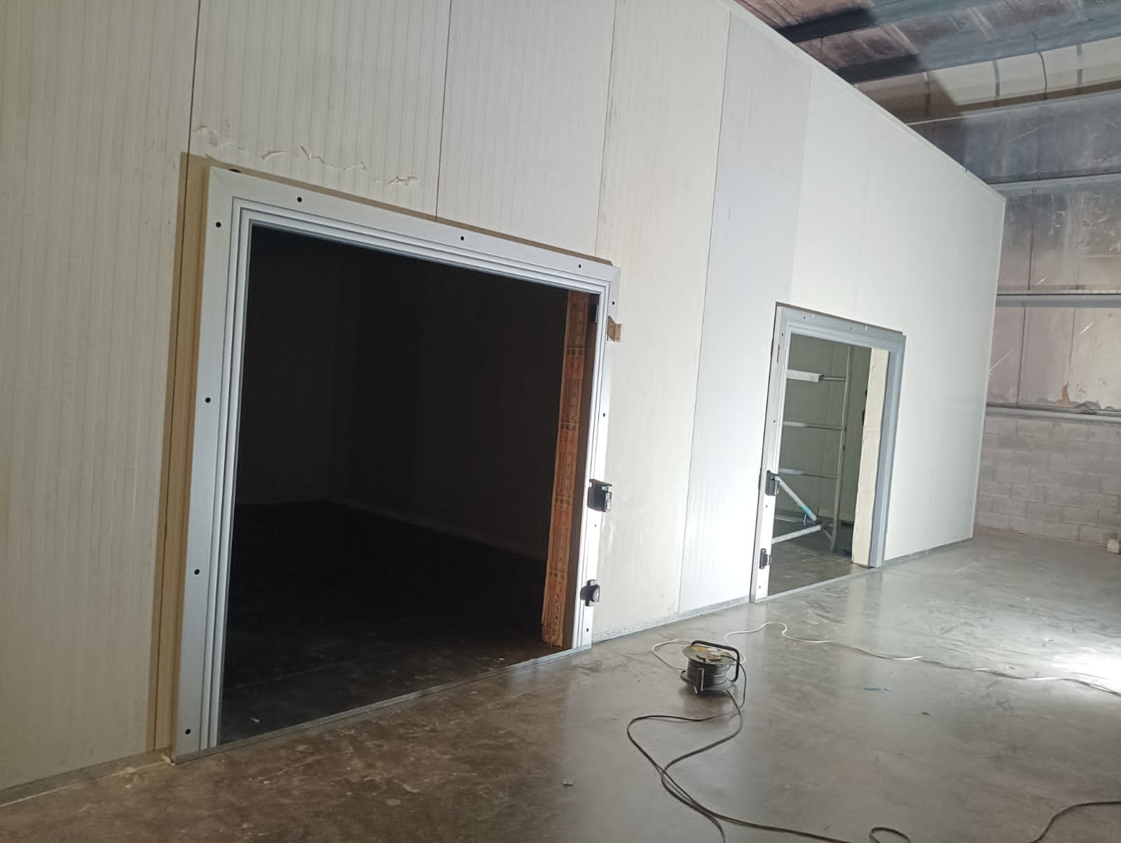 Multi-room cold store under construction with panel walls and door openings