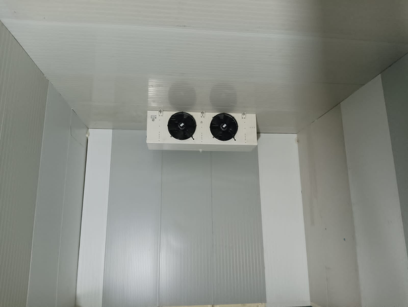 Twin-fan evaporator unit cooler mounted inside a walk-in cold room